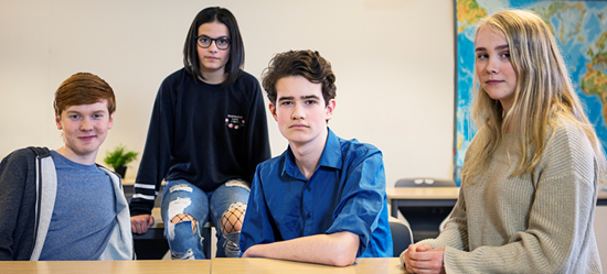 Fyra elever sitter i ett klassrum.