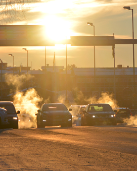 Bilar i kallt klimat som släpper ut avgaser i motljus.