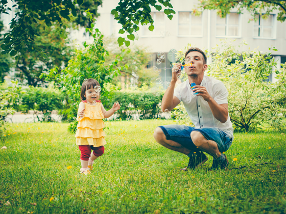 Barn och pappa blåser såpbubblor