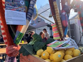 Pall med grönsaker och frukt på marknad.