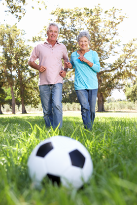 Två äldre personer med en fotboll