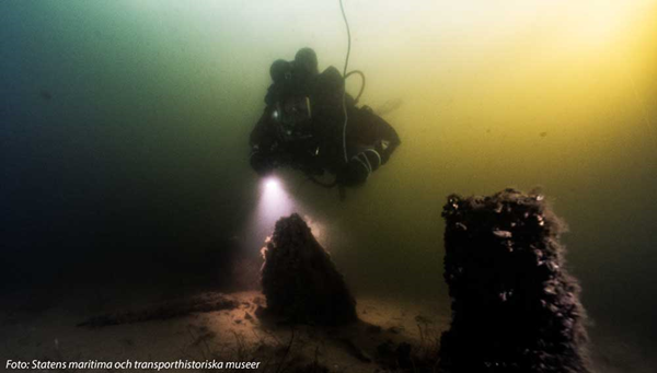 Foto på dykare och del av ett vrak. Foto: Statens maritima och transporthistoriska museer