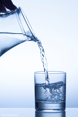 Vatten hälls i ett glas från en tillbringare.