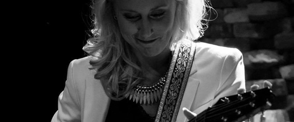 Foto på Frida Andersson som spelar på gitarr.