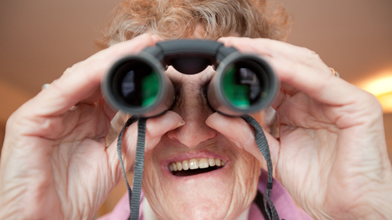 Äldre kvinna som tittar i kikare