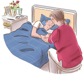 Personal vakar över äldre kvinna i säng