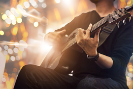 Bild på en person som spelar gitarr